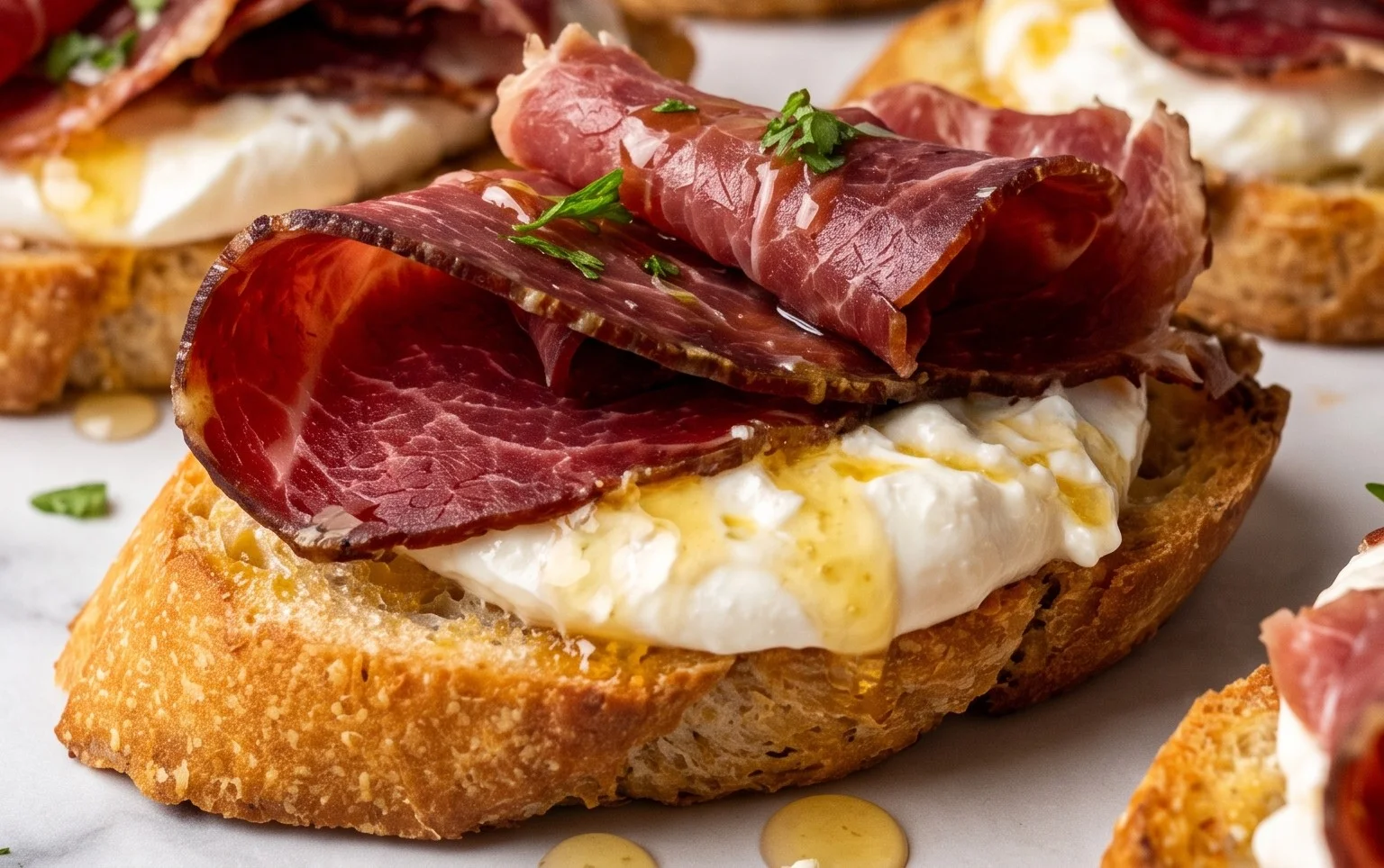 Beef Prosciutto Crostini with Burrata and Lemon Honey Drizzle
